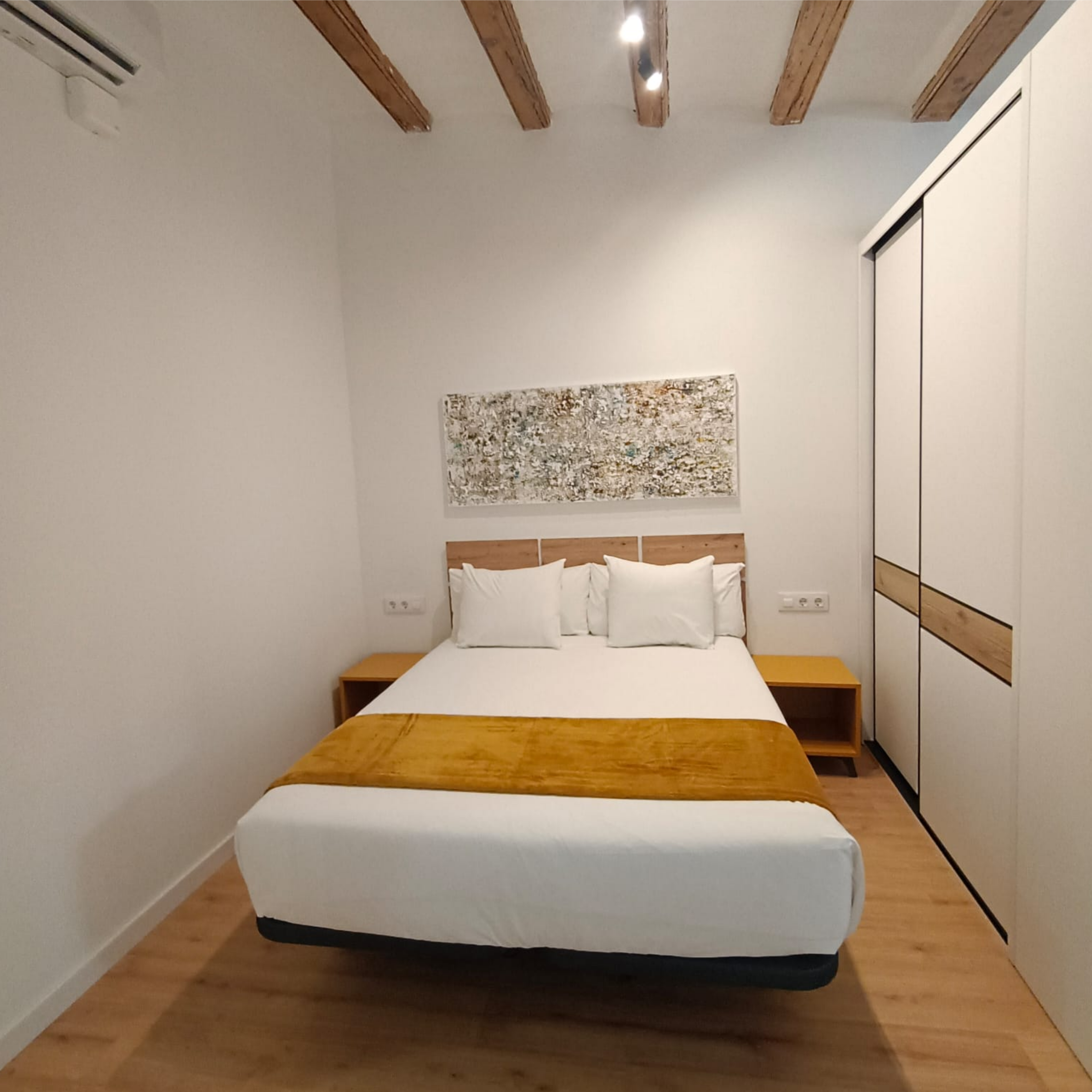 Dormitorio con cabecero de madera y detalles en blanco